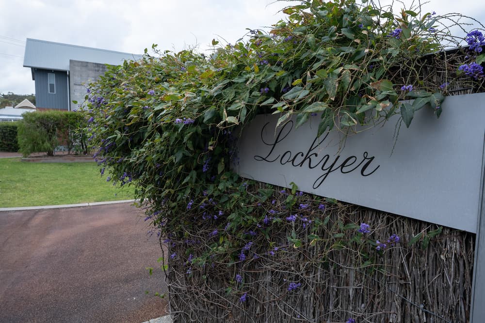 The sign for the Lockyer on a brush fence with a Hardenbergia climber over the top.